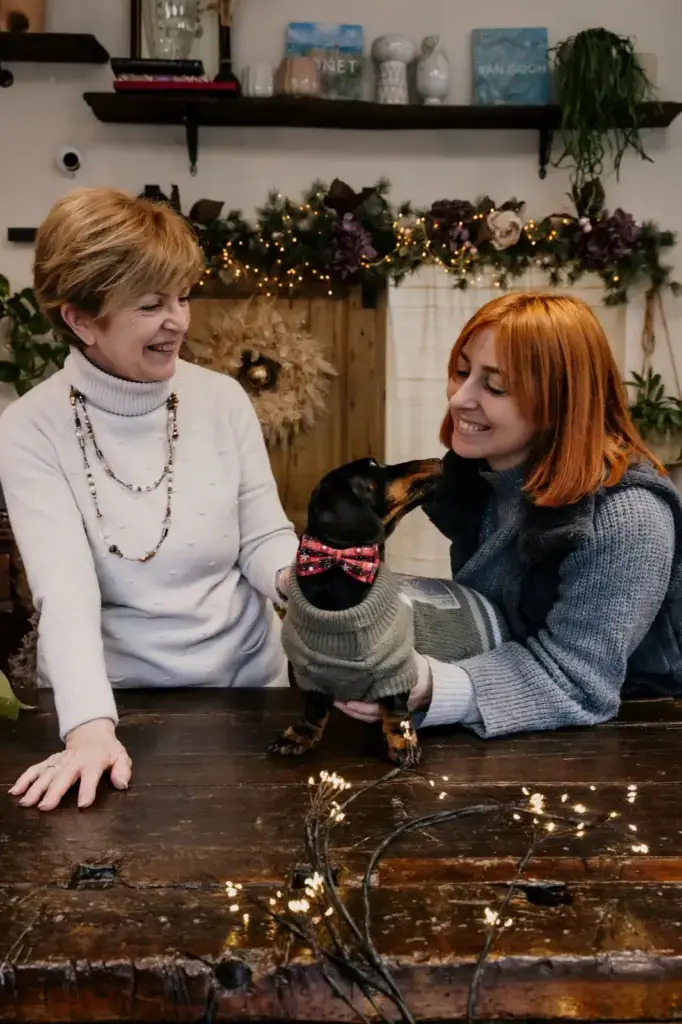 Giulia e la mamma Daniela dietro il banco della bottega, con il cane di casa