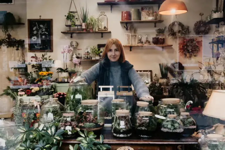 Il banco della bottega coperto di terrari di vetro di forme diverse
